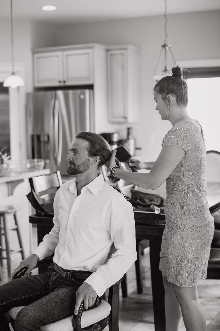 Black and white photo of groom getting hair done